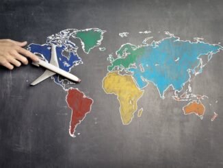 person with toy airplane on world map