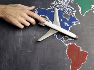 person with toy airplane on world map