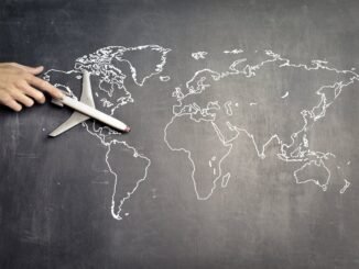 miniature airplane and hand of person over drawn map