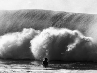 silhouette of anonymous man near wave