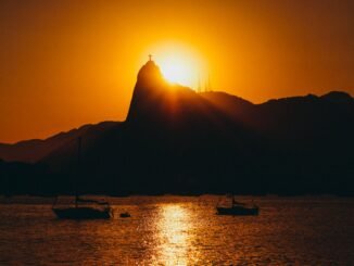 silhouette of two boats on body of water