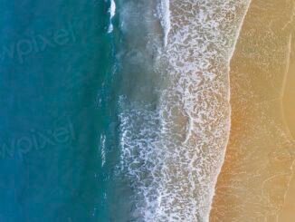 Ocean washing, sandy beach, drone
