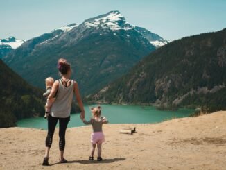mother and children walks near body of water