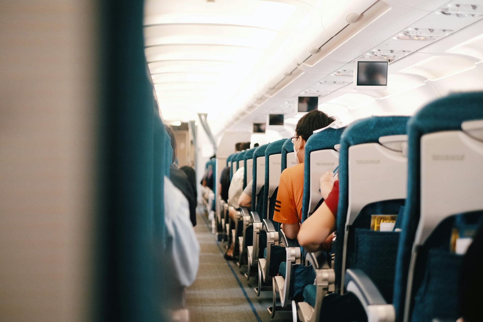 people sitting on blue seats inside an airplane