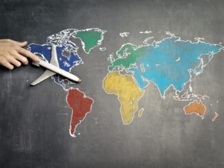 person with toy airplane on world map
