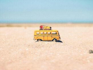 yellow die cast miniature van on brown sand
