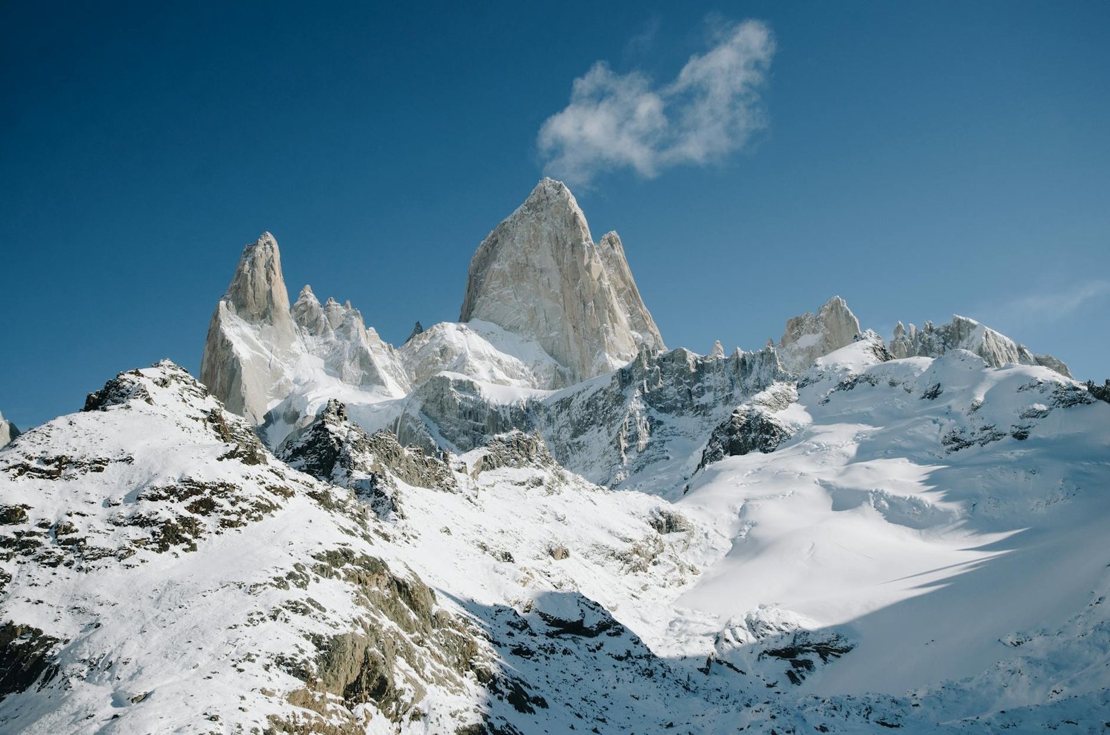 peak of the mountains covered in snow under a blue sky