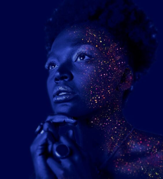 fashion photography of woman hands on chin with glitter makeup