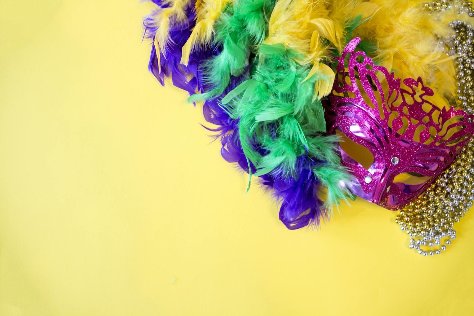 carnival mask and feathers on yelllow background