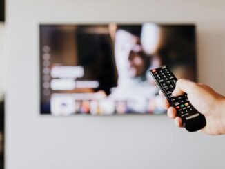 person pressing the button of a remote control
